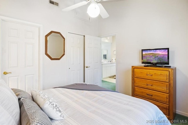 carpeted bedroom featuring baseboards, a ceiling fan, visible vents, and ensuite bathroom