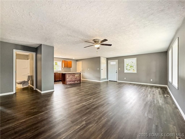 3053 Doc Ridgeway Dr, Roach, MO 65787 - unfurnished living room featuring a ceiling fan, dark wood-style flooring, baseboards, and a textured ceiling