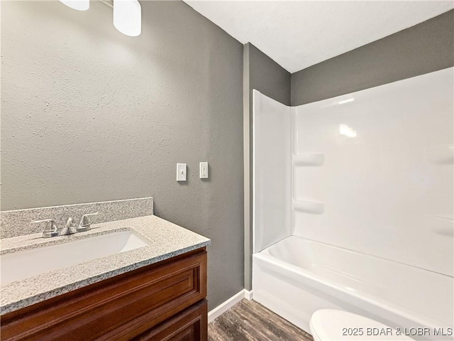 3053 Doc Ridgeway Dr, Roach, MO 65787 - bathroom featuring wood finished floors, vanity, baseboards, toilet, and bathtub / shower combination