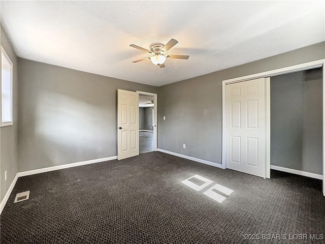 3053 Doc Ridgeway Dr, Roach, MO 65787 - unfurnished bedroom featuring baseboards, dark carpet, a ceiling fan, and a closet