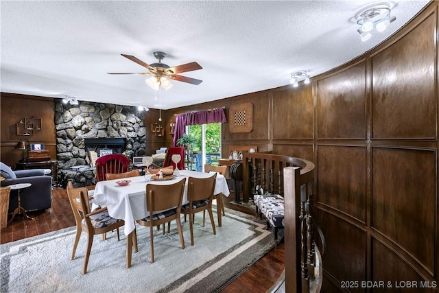 31945 Idle Wild Rd, Gravois Mills, MO 65037 - dining area featuring a textured ceiling, ceiling fan, wood finished floors, and a fireplace