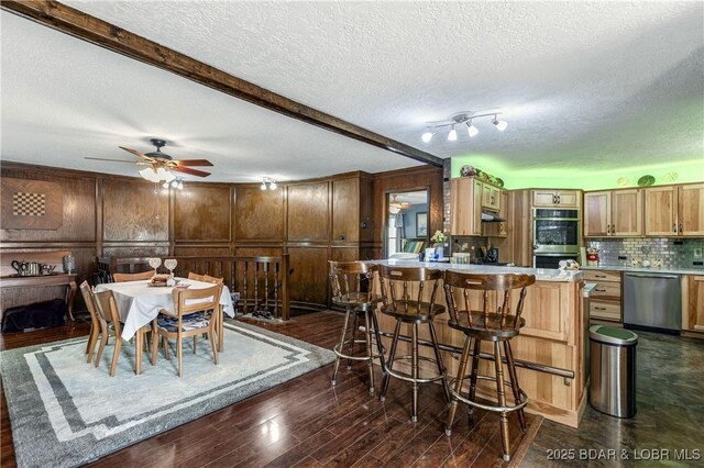 31945 Idle Wild Rd, Gravois Mills, MO 65037 - dining area with beam ceiling, a ceiling fan, dark wood-style floors, and a textured ceiling