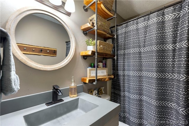 full bath featuring a shower with curtain, a textured ceiling, and vanity