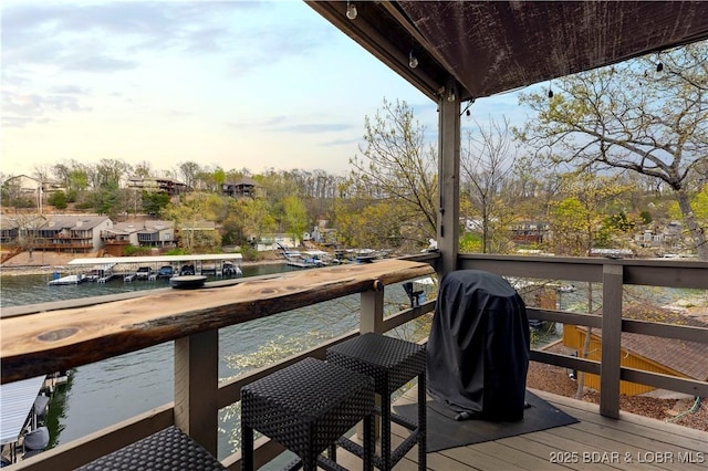 wooden deck with grilling area and a water view