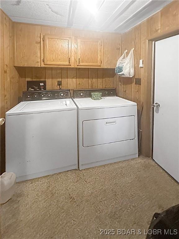 796 1051st Rd SE, Mo, MO 64740 - clothes washing area with washing machine and dryer, wooden walls, and cabinet space