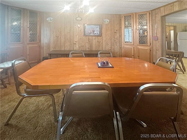 796 1051st Rd SE, Mo, MO 64740 - dining area featuring carpet flooring and wood walls