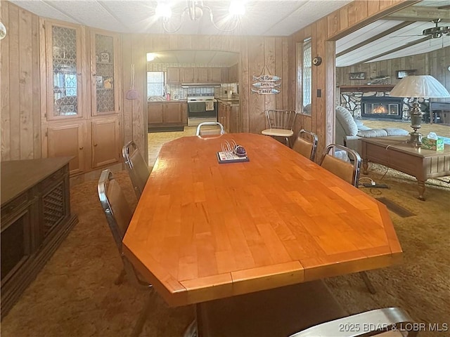 796 1051st Rd SE, Mo, MO 64740 - carpeted dining room featuring wooden walls and a ceiling fan