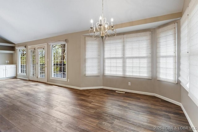 spare room with vaulted ceiling, a chandelier, wood-type flooring, and baseboards