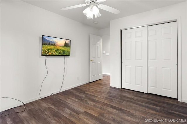 unfurnished bedroom with dark wood-style flooring, a closet, a ceiling fan, and baseboards