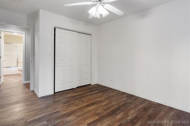 unfurnished bedroom with dark wood-style floors, baseboards, a closet, and ceiling fan