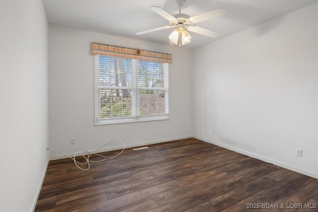 empty room featuring baseboards, wood finished floors, and a ceiling fan