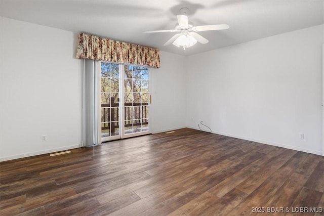 unfurnished room featuring dark wood-type flooring, a ceiling fan, and baseboards