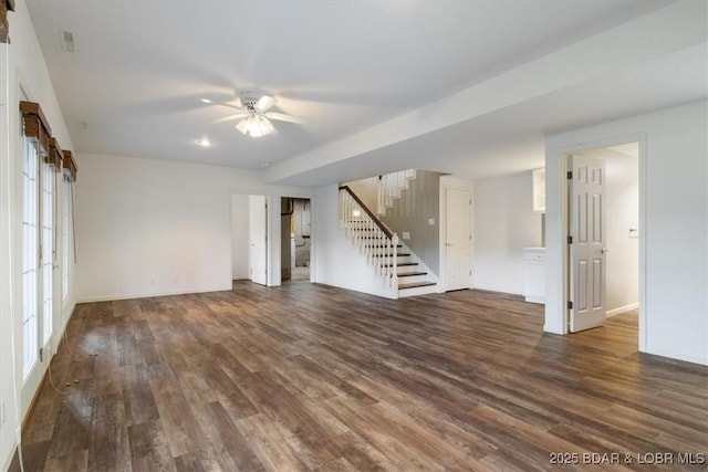 unfurnished living room featuring stairs, wood finished floors, ceiling fan, and baseboards