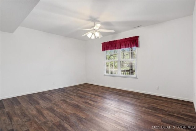 spare room featuring wood finished floors, a ceiling fan, and baseboards