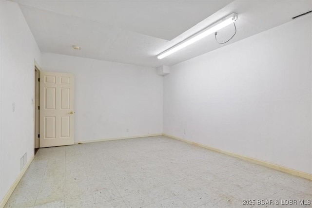spare room with tile patterned floors and baseboards