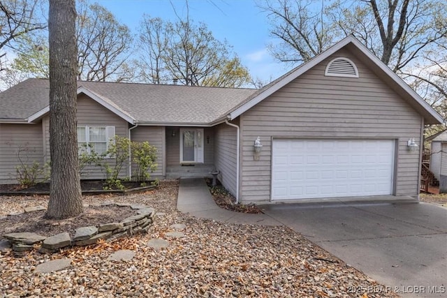 ranch-style home with driveway, an attached garage, and roof with shingles