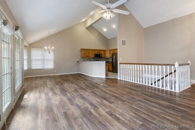 unfurnished living room featuring high vaulted ceiling, a chandelier, wood finished floors, ceiling fan, and baseboards