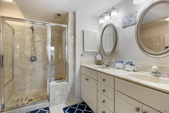 bathroom featuring double vanity, tile patterned floors, a stall shower, and a sink