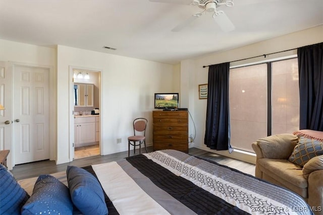 bedroom featuring ensuite bath, a ceiling fan, wood finished floors, and visible vents