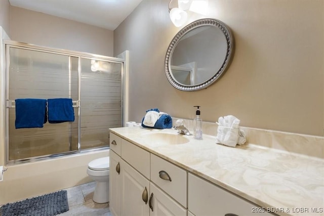 full bathroom with combined bath / shower with glass door, toilet, and vanity