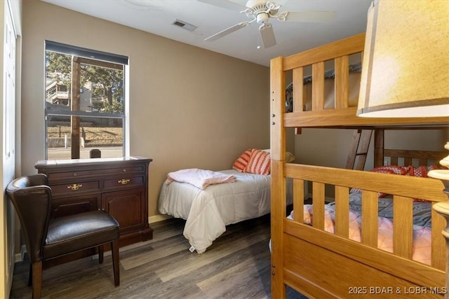 bedroom with a ceiling fan, visible vents, and dark wood-type flooring