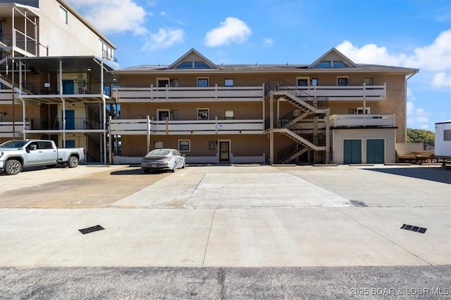 view of property featuring stairs and uncovered parking