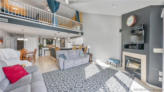 75 Cedar Heights Ln Unit 4D, Camdenton, MO 65020 - living area with light tile patterned floors, a chandelier, a tiled fireplace, and a towering ceiling