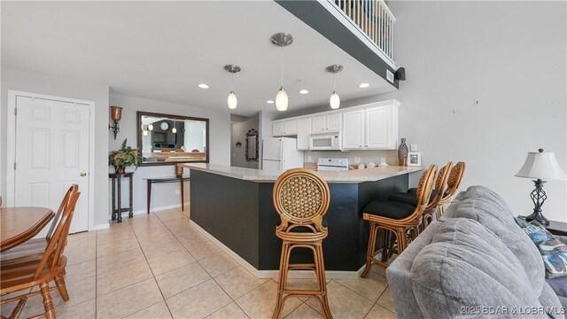 75 Cedar Heights Ln Unit 4D, Camdenton, MO 65020 - kitchen with white appliances, light countertops, white cabinets, a peninsula, and recessed lighting