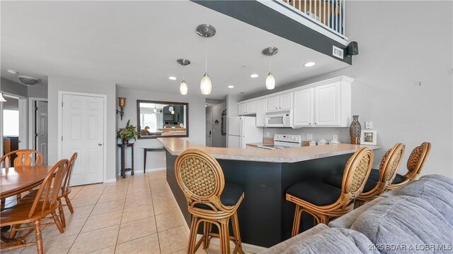 75 Cedar Heights Ln Unit 4D, Camdenton, MO 65020 - kitchen with white appliances, a peninsula, white cabinets, plenty of natural light, and recessed lighting