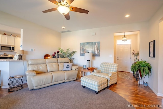 living room featuring wood finished floors, a ceiling fan, and recessed lighting