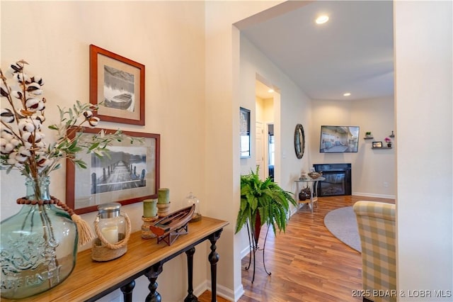 hall with wood finished floors, baseboards, and recessed lighting