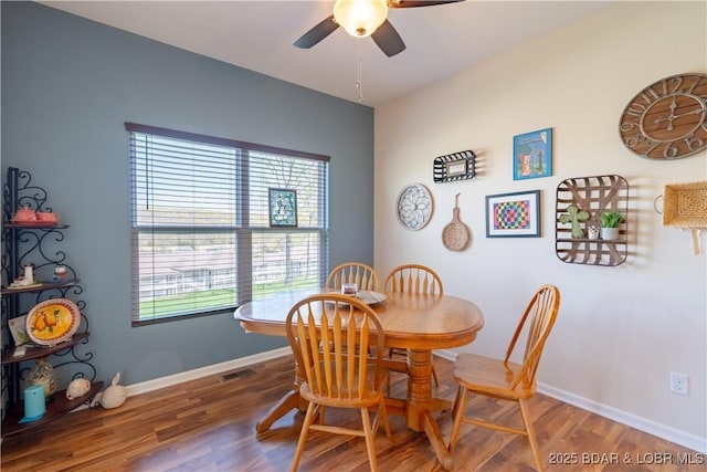 dining room featuring a ceiling fan, wood finished floors, and baseboards