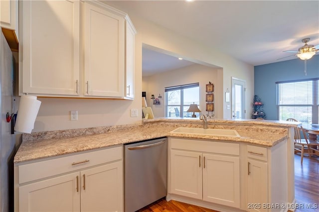 kitchen with dishwasher, a sink, a peninsula, white cabinetry, and ceiling fan