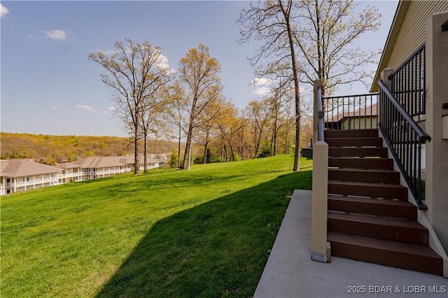view of grassy yard featuring stairway