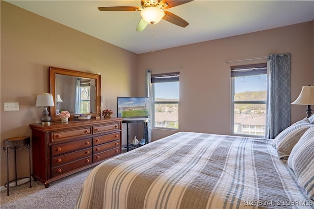 bedroom with multiple windows, light carpet, and a ceiling fan