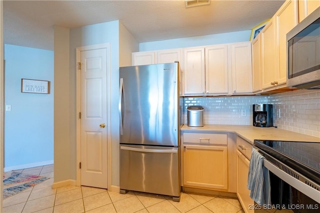 245 Bristol Bay Dr Unit 2B, Lake Ozark, MO 65049 - kitchen featuring stainless steel appliances, light tile patterned floors, backsplash, and light countertops