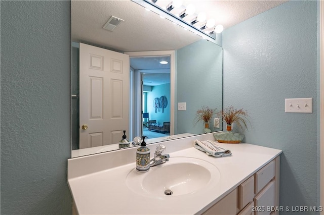 245 Bristol Bay Dr Unit 2B, Lake Ozark, MO 65049 - bathroom with a textured wall, vanity, and a textured ceiling
