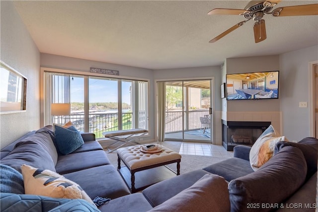 245 Bristol Bay Dr Unit 2B, Lake Ozark, MO 65049 - living area featuring a fireplace, ceiling fan, light tile patterned floors, and a textured ceiling