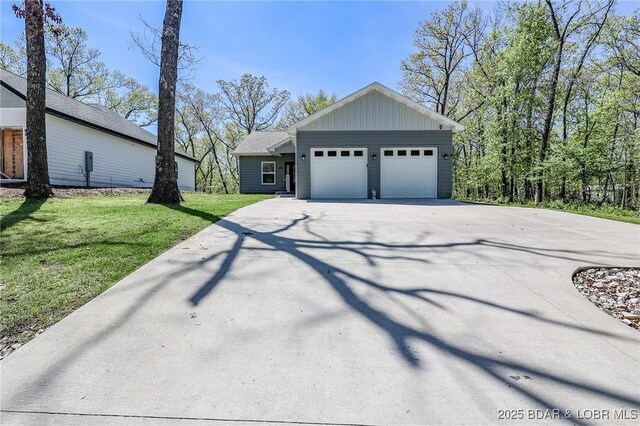 284 Bloomington Dr, Lake Ozark, MO 65049 - view of front of house with driveway, an attached garage, and a front yard