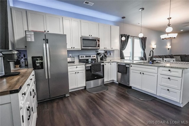 284 Bloomington Dr, Lake Ozark, MO 65049 - kitchen with appliances with stainless steel finishes, a peninsula, dark wood-style flooring, and white cabinets