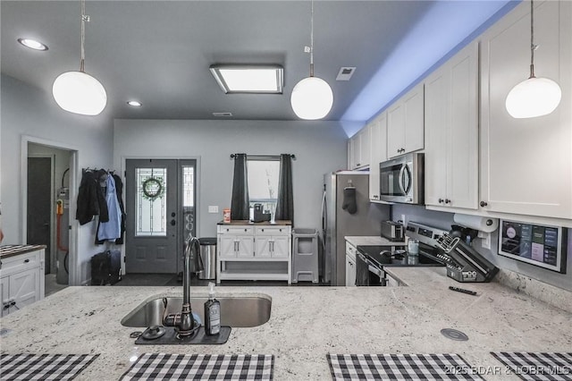 284 Bloomington Dr, Lake Ozark, MO 65049 - kitchen with stainless steel appliances, light stone countertops, decorative light fixtures, white cabinets, and recessed lighting