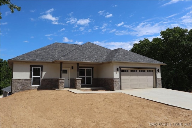 25 Sam Dr, Kaiser, MO 65047 - view of front of home with stucco siding, stone siding, a garage, driveway, and a shingled roof