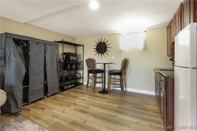 dining room featuring baseboards and light wood-style floors