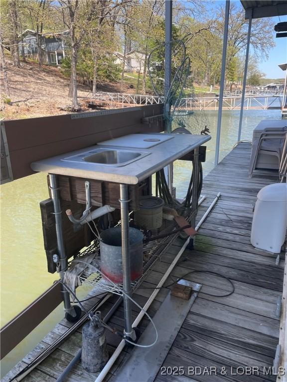 wooden deck featuring a boat dock and a water view