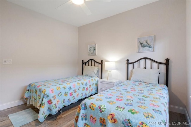 bedroom featuring wood finished floors, a ceiling fan, and baseboards