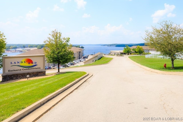 view of property's community featuring a lawn and a water view