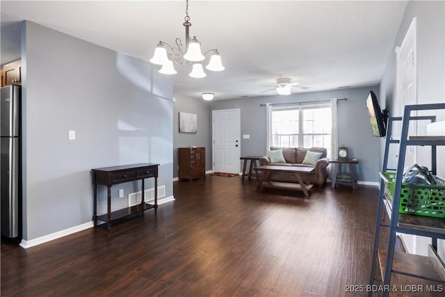 living area with baseboards, ceiling fan with notable chandelier, and wood finished floors