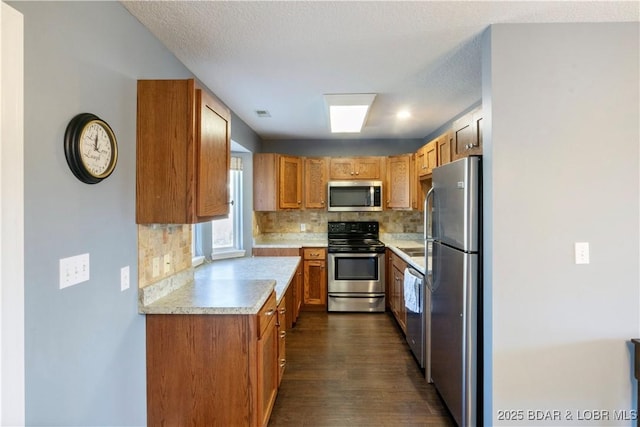 kitchen featuring light countertops, decorative backsplash, stainless steel appliances, and dark wood-style flooring