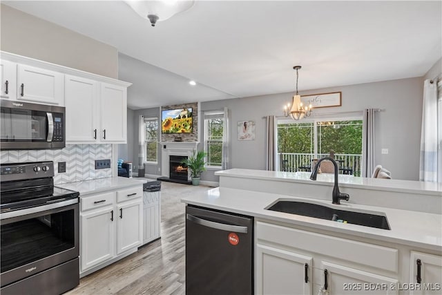 63 Lancelot Ct, Camdenton, MO 65020 - kitchen with appliances with stainless steel finishes, a sink, light countertops, white cabinets, and recessed lighting