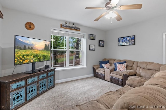 living area with ceiling fan, baseboards, and carpet floors